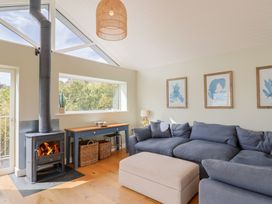 A living room with a wood stove and sofa at 13 Downside Close in Charmouth