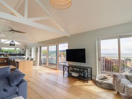A living room with a television and sofa at 13 Downside Close in Charmouth
