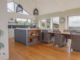 A kitchen with a dining area and large windows at 13 Downside Close Charmouth