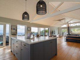 A kitchen with an island and windows overlooking the sea at 13 Downside Close in Charmouth