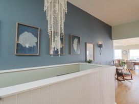 A hallway with wall art and a chandelier at 13 Downside Close in Charmouth