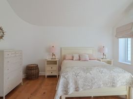 A bedroom with a bed, nightstands, and a dresser at 13 Downside Close in Charmouth