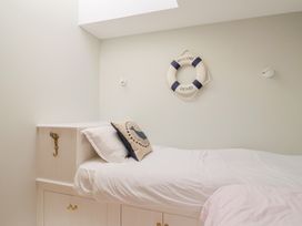 A bedroom with a bed and life preserver decoration at 13 Downside Close, Charmouth