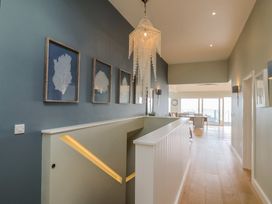 A hallway with a chandelier and wall art at 13 Downside Close in Charmouth