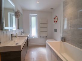 A bathroom with a bath tub and sink at 13 Downside Close Charmouth