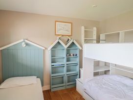 A bedroom with bunk beds and a bookshelf at 13 Downside Close in Charmouth