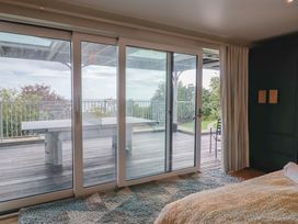 A bedroom with a window and balcony view at 13 Downside Close in Charmouth