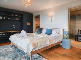 A bedroom with a bed, nightstand, and a shelf at 13 Downside Close in Charmouth