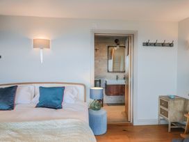 A bedroom with a bed and bathroom entrance at 13 Downside Close in Charmouth
