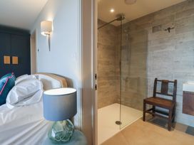 A bedroom with a bed and a shower area at 13 Downside Close in Charmouth