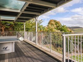 A balcony with a table overlooking greenery at 13 Downside Close Charmouth
