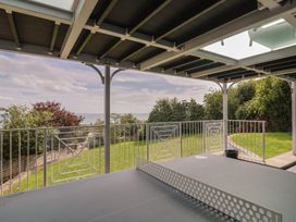 A balcony overlooking a garden and sea at 13 Downside Close Charmouth