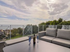 An outdoor terrace with a sofa and table at 13 Downside Close in Charmouth
