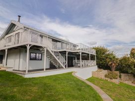 A two-story house with a balcony and garden at 13 Downside Close in Charmouth