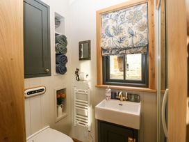 A bathroom with a sink under a window with patterned blind at Evendine Hut @ Evendine Cottage in Colwall Herefordshire