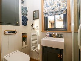 A bathroom with a toilet sink towels and a window at Evendine Hut @ Evendine Cottage in Colwall Herefordshire