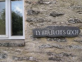 Window with a slate sign on stone wall at The Long House in Penmachno