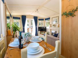 A dining room with a table set for meals at 25 Foxburrow Hang in Fritton near Belton