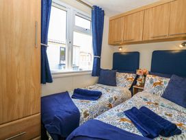 A bedroom with two beds and a window at 25 Foxburrow Hang in Fritton near Belton