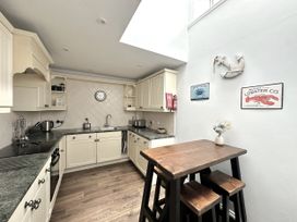A kitchen with a table and chairs at Melanie's Cottage Brewers Quay Harbour