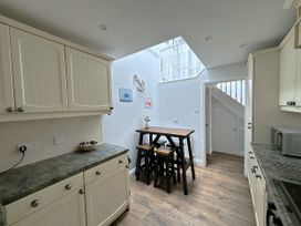 A kitchen with cabinets and a table at Melanie's Cottage Brewers Quay Harbour
