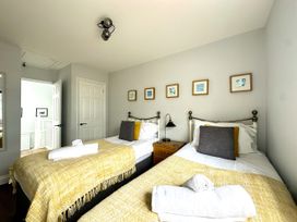 A bedroom with two beds and a mirror at Melanie's Cottage in Brewers Quay Harbour