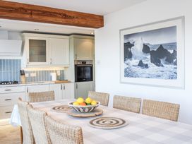 A dining room with a table and fruit bowl at Firm Anchor in Salcombe