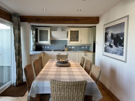 A kitchen with a dining table and chairs at Firm Anchor in Salcombe