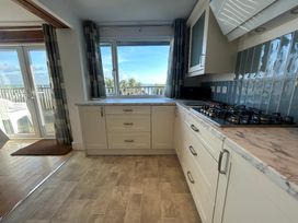A kitchen with cabinets and a view at Firm Anchor in Salcombe