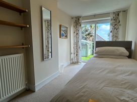 A bedroom with a bed and shelves at Firm Anchor in Salcombe
