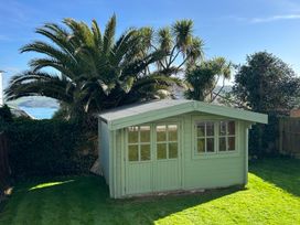 A garden shed surrounded by palm trees at Firm Anchor in Salcombe