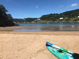 A beach with a kayak in the foreground at Firm Anchor in Salcombe