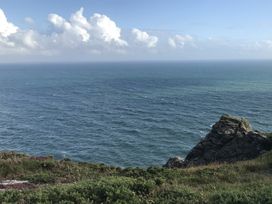 A view of the ocean and clouds from a rocky area at Firm Anchor in Salcombe