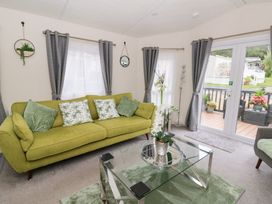 A living room with a green sofa and glass table at The Haven