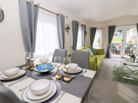 A living room with a dining area and green couch at The Haven in 