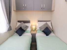 A bedroom with two single beds and a lamp on a shared bedside table at The Haven