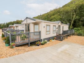 A mobile home with a deck and landscaping at The Haven in 