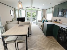 A living room with a sofa, table, and television at Heather William Lodge near Woodhall Spa