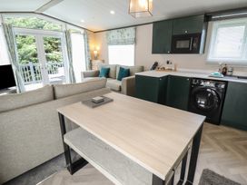 A living room with a sofa and dining table at Heather William Lodge near Woodhall Spa
