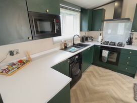 A kitchen with appliances including a stove and washing machine at Heather William Lodge near Woodhall Spa
