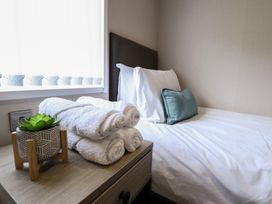 A bedroom with a bed and towels on a nightstand at Heather William Lodge near Woodhall Spa
