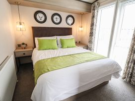 A bedroom with a double bed and nightstand at Heather William Lodge near Woodhall Spa