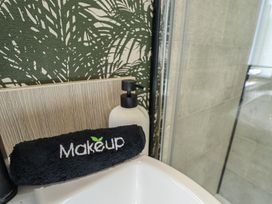A sink with a towel and soap dispenser at Heather William Lodge near Woodhall Spa