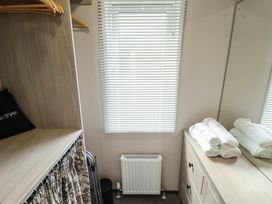 A bedroom with a wardrobe and towels at Heather William Lodge near Woodhall Spa