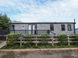 An exterior view of a lodge with a deck and steps at Heather William Lodge near Woodhall Spa