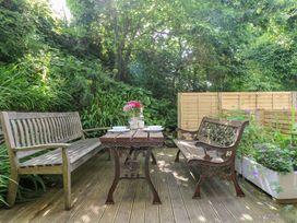 A garden with a wooden table and benches at Oofoo’s Barn in Mullion