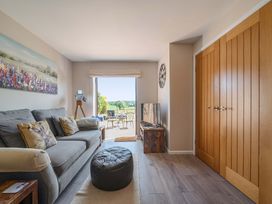 A living room with a sofa and television at Piglet Corner in Culmstock