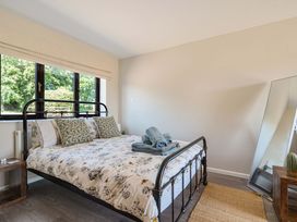 A bedroom with a bed and mirror at Piglet Corner in Culmstock