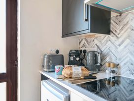 A kitchen with appliances and bread on the counter at Piglet Corner in Culmstock