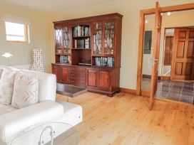 A living room with a bookshelf and sofa at Cashelrehine in Falcarrheh